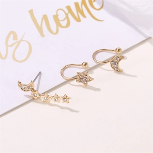 Detail of gold star and moon clip-on earrings set with sparkling rhinestones