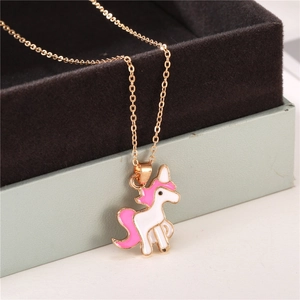 Détail macro d'un pendentif licorne en émail sur une chaîne dorée dans un écrin