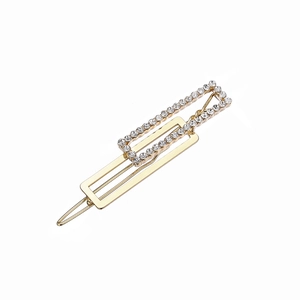 Macro shot of gold-plated rectangular hair clip with shimmering white crystal rhinestones