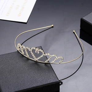 Elegant gold heart-shaped rhinestone crown headband for girls on black leather background