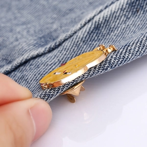 Cute yellow duck enamel brooch with gold-tone base pinned on blue denim jacket fabric