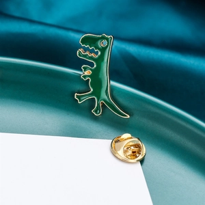 Detailed close-up of dark green dinosaur brooch with golden edges and metal clutch