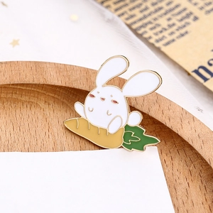 Broche en émail lapin mignon avec carotte sur plateau en bois et carte blanche