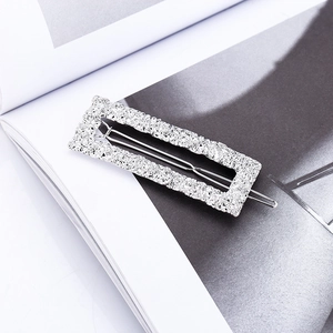 Three-piece set of textured silver metal hair clips on a fashion magazine background