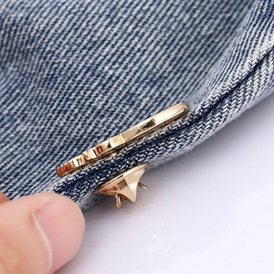 Broche fleur dorée mignonne sur tissu denim bleu avec fermeture papillon en métal