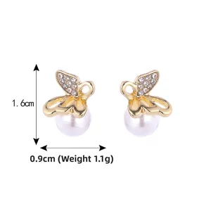 Detail view of gold butterfly earrings with pearl and zircons, size 1.6cm by 0.9cm