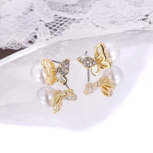 Elegant gold butterfly pearl stud earrings with sparkling crystals and lace background