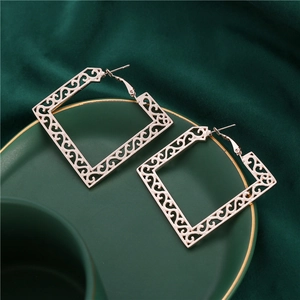 Boucles d'oreilles carrées bohèmes évidées en or rose avec motif filigrane sur velours