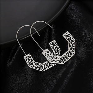 Bohemian silver hollow geometric earrings with intricate floral patterns on black silk