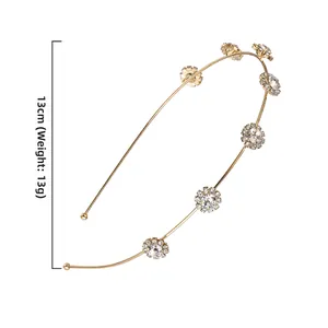 Detail view of 13cm golden metal headband with seven sparkling rhinestone flowers