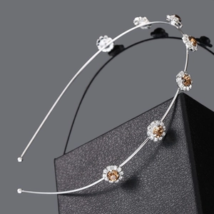 Detailed macro of a silver headband with amber gemstone flowers and crystal rhinestones