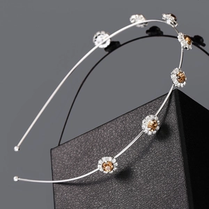Close-up of thin silver alloy headband with amber crystals and sparkling rhinestones