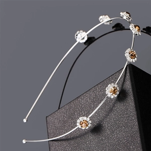 Close-up of silver headband with flower-shaped crystal clusters and amber center stones