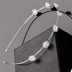 Detailed view of silver hairband featuring six sparkling crystal floral arrangements