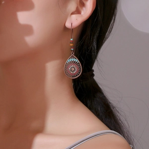 Boucles d'oreilles bohèmes en bronze mandala avec perles colorées sur un mannequin