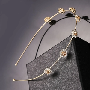Close-up of golden floral headband with amber stones on black textured gift box