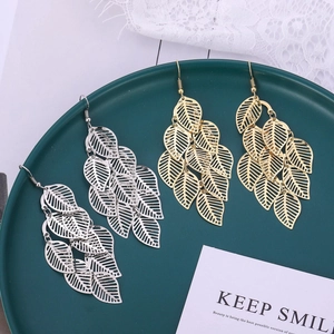 Vue détaillée de boucles d'oreilles feuilles évidées multicouches dorées et argentées