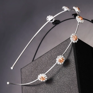 Detail of silver headband with amber crystal flowers and white rhinestones on gift box