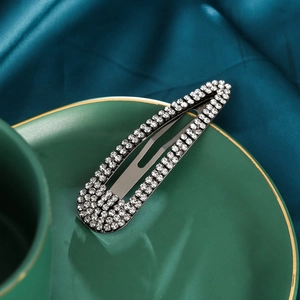 Elegant silver teardrop BB hair clip with sparkling rhinestones on green silk background