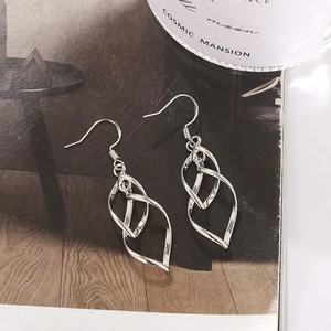 Fashionable twisted geometric silver leaf earrings on a minimalist lifestyle backdrop