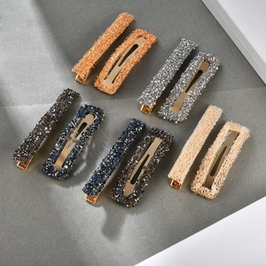 Detail view of 10-piece glitter rectangular hair clip set in five diverse colors