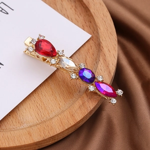 Barrette élégante en alliage doré avec pierres précieuses colorées sur un plat