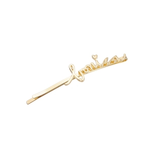 Gros plan d'une barrette Love dorée polie avec un petit détail de cœur en relief 3D