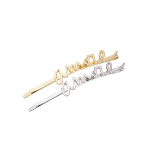 Détail macro de barrettes en alliage or et argent avec lettrage amore cursif