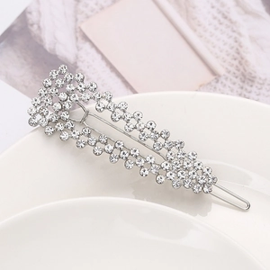 Dettaglio di eleganti fermagli per capelli con strass su un piatto di ceramica bianca