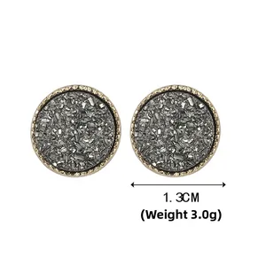 Detailansicht der 1,3 cm Druzy-Ohrstecker mit gezacktem Goldrand und grauer Kristalltextur
