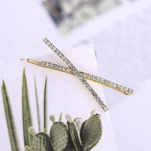 Elegant pair of gold-tone hair clips with sparkling rhinestones in a cross pattern