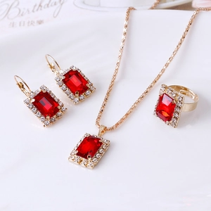 Elegantes Goldschmuck-Set mit roten Kristallen im Treppenschliff und weißen Akzenten