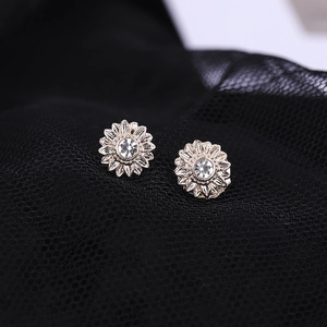 Elegant gold sunflower stud earrings with crystal center on a black mesh background