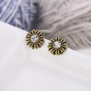 Elegant vintage gold sunflower stud earrings with central crystal stone in white ceramic tray