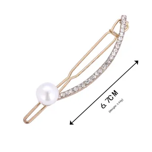 Detail of 6.7cm gold U-shaped hair clip with sparkling rhinestones and a white pearl