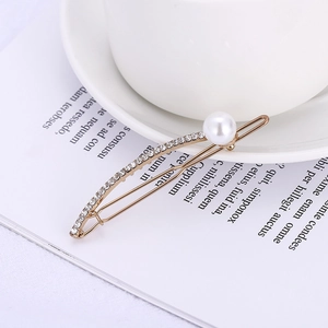 Elegant gold U-shaped hair clip with sparkling rhinestones and a large white pearl detail
