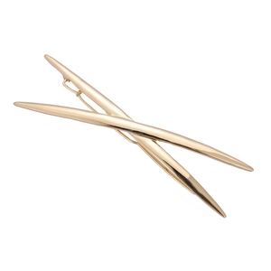Polished gold X-shaped minimalist hair clip with a sleek crossing metal design