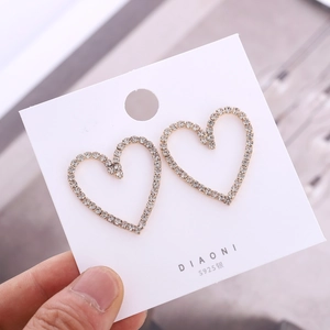 Detail of 925 silver heart stud earrings with sparkling pavé white rhinestones