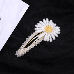 Vue détaillée d'une barrette fleur marguerite en perles avec base en métal doré brillant