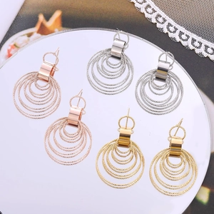 Three pairs of multilayer circle earrings in gold, rose gold and silver on mirror