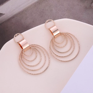 Close-up of rose gold layered round earrings with sparkling diamond cut texture details