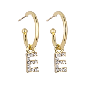 Close-up of golden letter E earrings with shimmering crystals and elegant hoop design