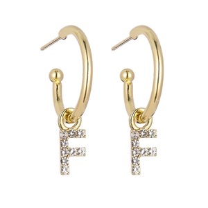 Detailed view of gold hoop earrings with sparkling crystal-encrusted letter F pendant