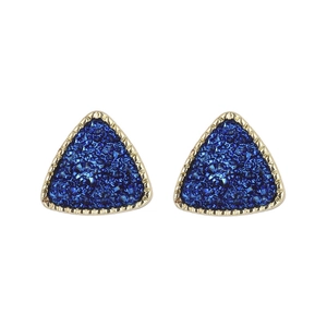 Dettaglio degli orecchini a triangolo in resina blu con bordi metallici dorati lavorati