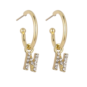 Detail of gold letter N earrings featuring sparkling pave set rhinestones on white backdrop