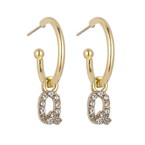 Detail view of gold letter Q pendant earrings featuring micro-pave cubic zirconia crystals