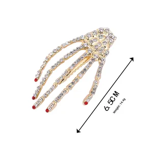Detail view of skeleton hand hair clip with white and red rhinestones measuring 6.5CM long