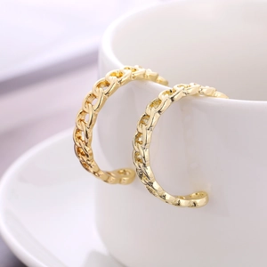 Chic gold-plated C-shaped hoop earrings with chain link texture on a white cup rim