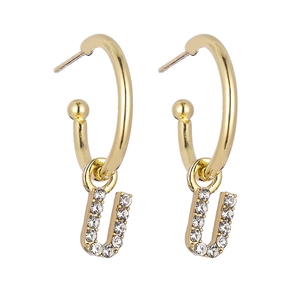 Close-up of gold letter U drop earrings featuring sparkling micro-pave cubic zirconia