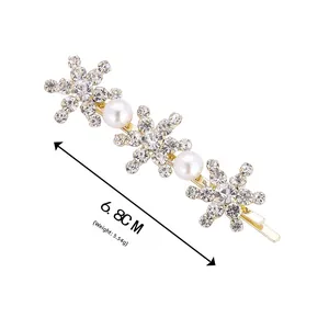 Détail de la barrette flocon dorée de 6,8 cm avec strass brillants et perles blanches